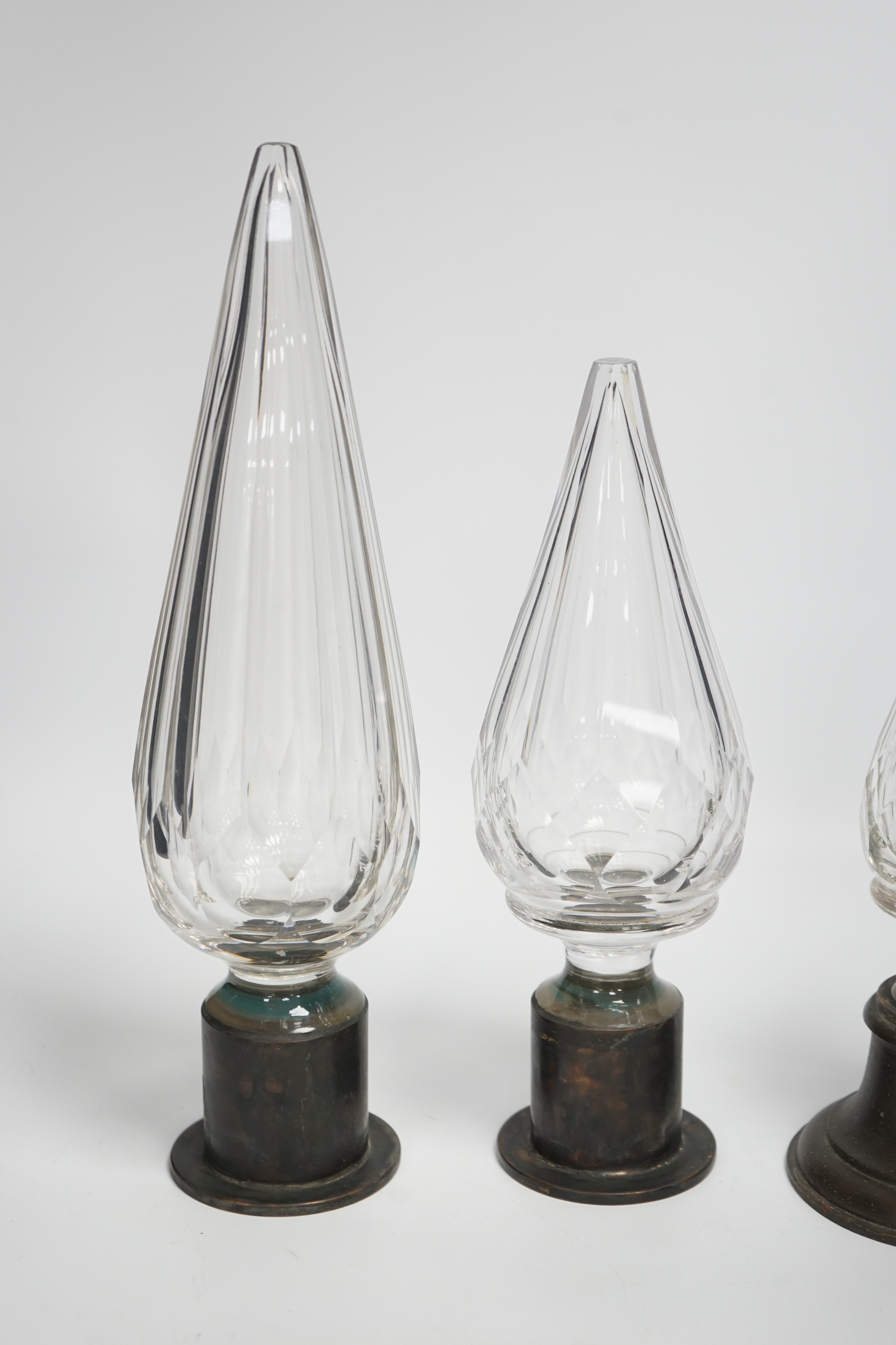 Three Large cut glass stoppers mounted on brass bases, highest 32.5cm